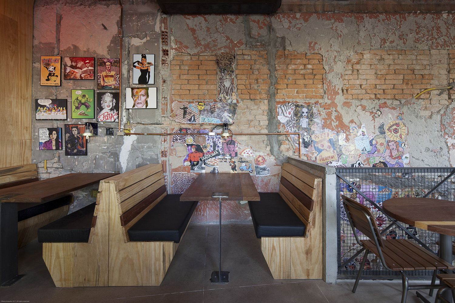 Weathered walls of the pizza restaurant with framed photographs and posters