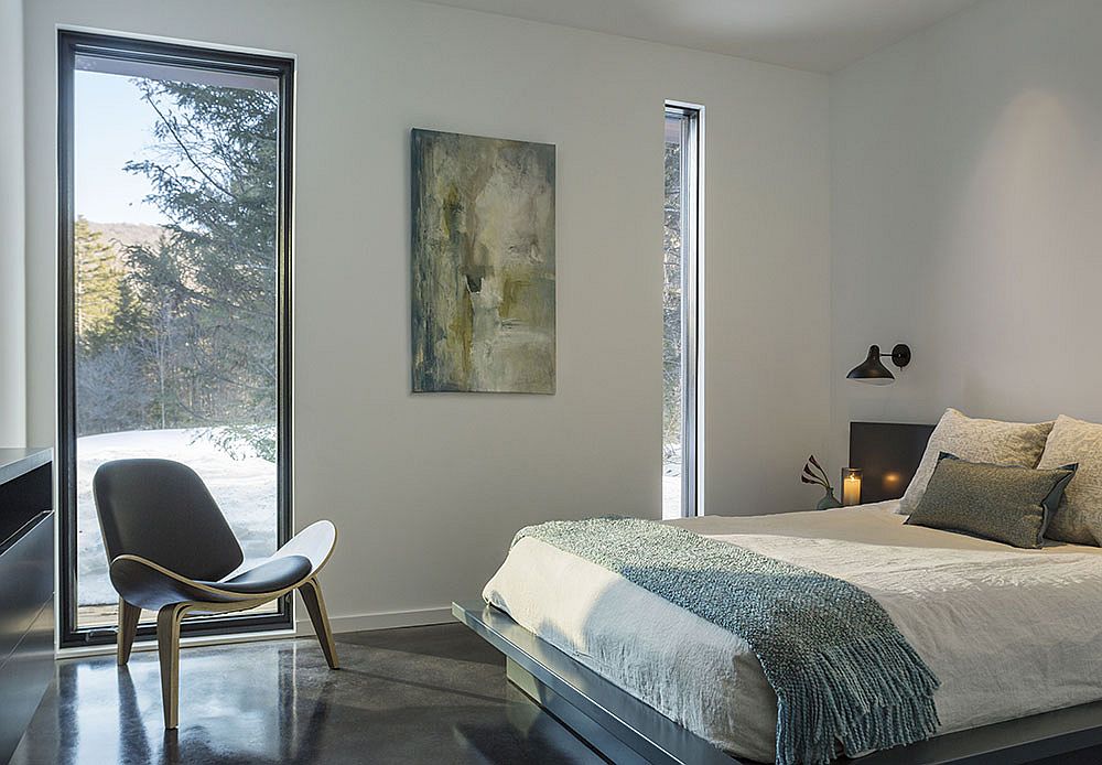 Bedroom with a view of the snow-covered meadows and the woods beyond