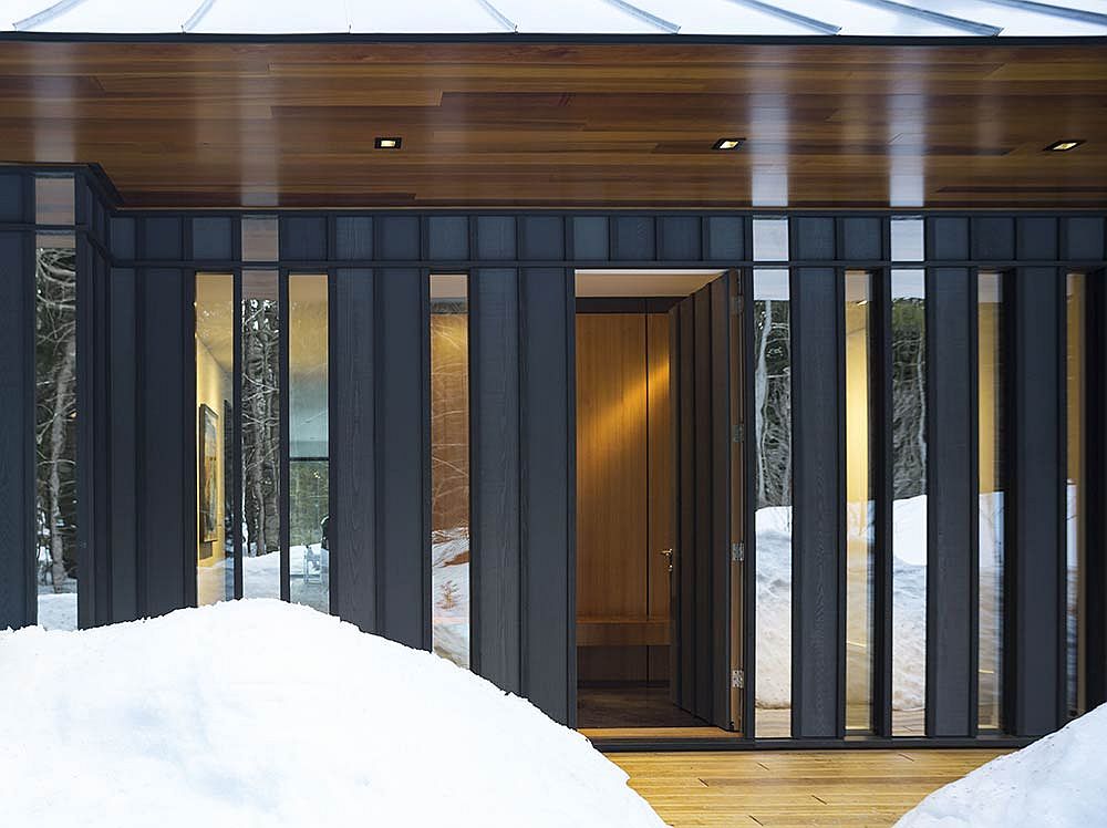 Carefully concealed entrance surrounded by the board and batten exterior of the house