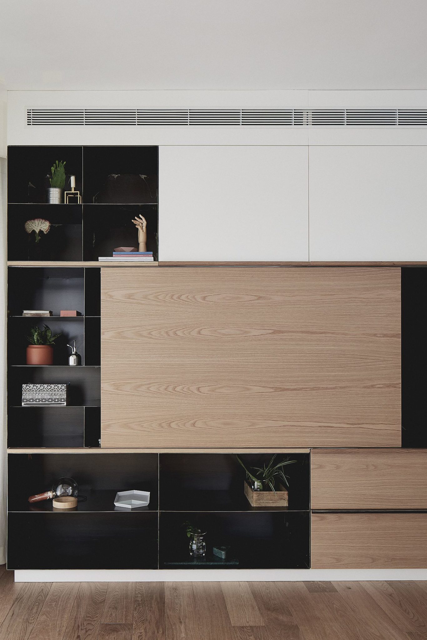 Dark cabinet with metallic elements and sliding wooden doors for the living room entertainment unit