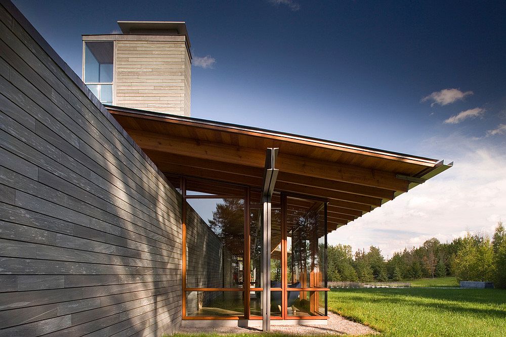 Douglas-fir-rafters-supported-by-steel-columns-along-with-glass-windows-create-a-charming-deck