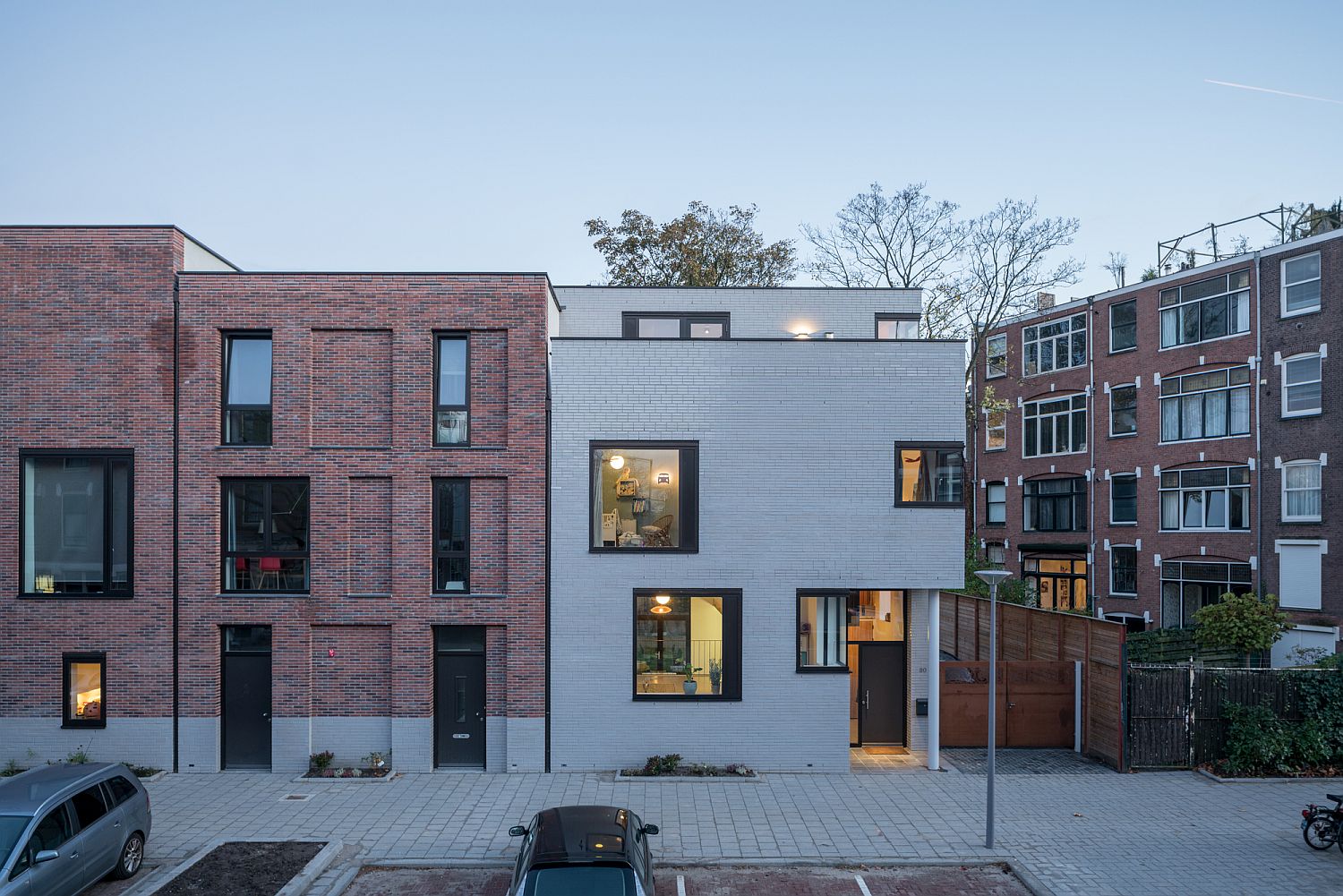 Exterior of the home in plain white bricks and lovely framed windows