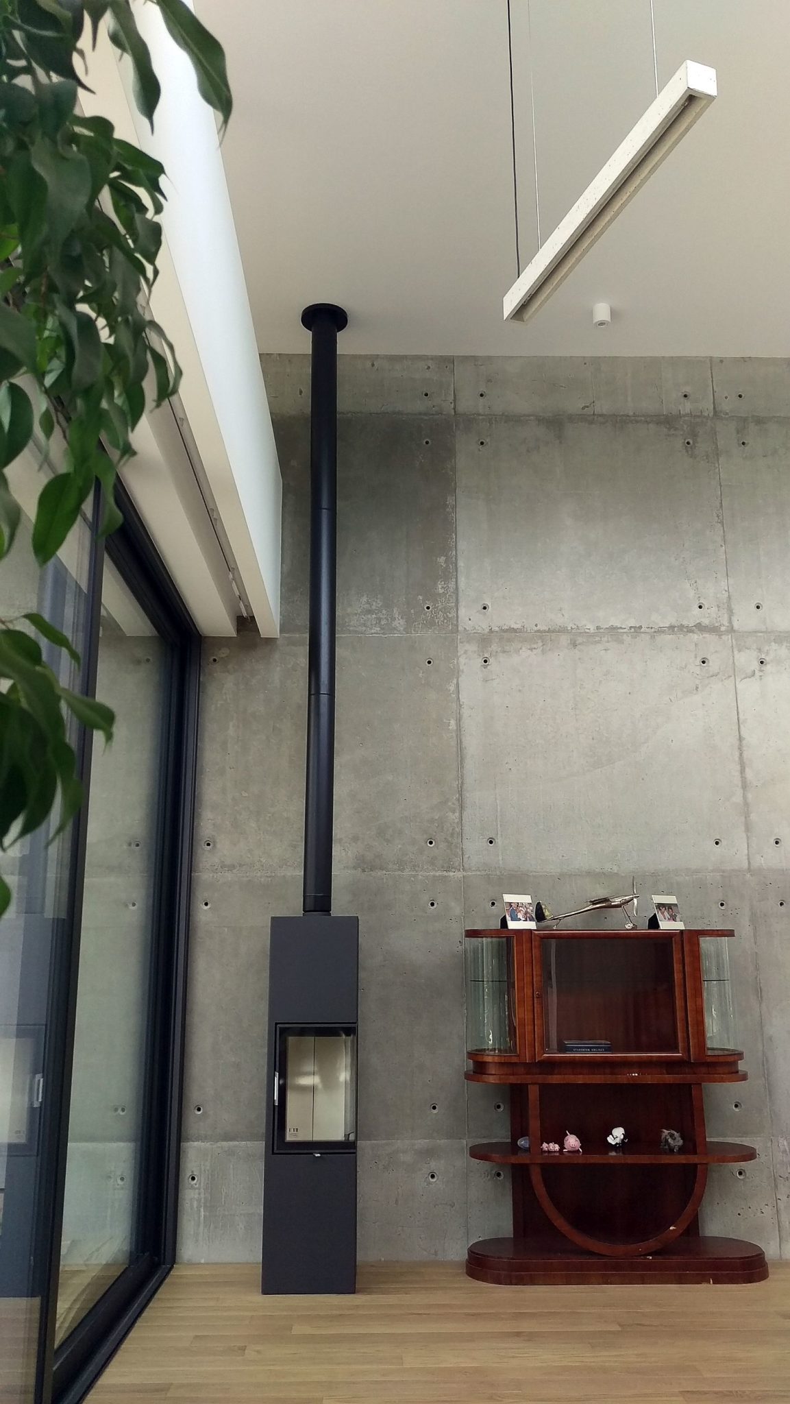 Fireplace in the corner next to the accent concrete wall