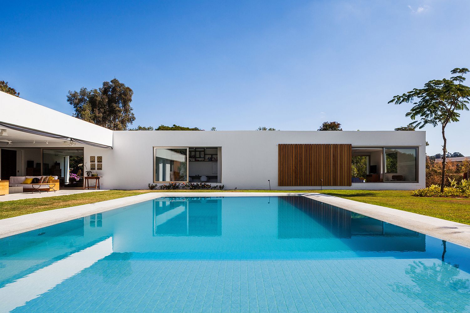 Floor-to-ceiling windows and an open design connect the interior with the pool area