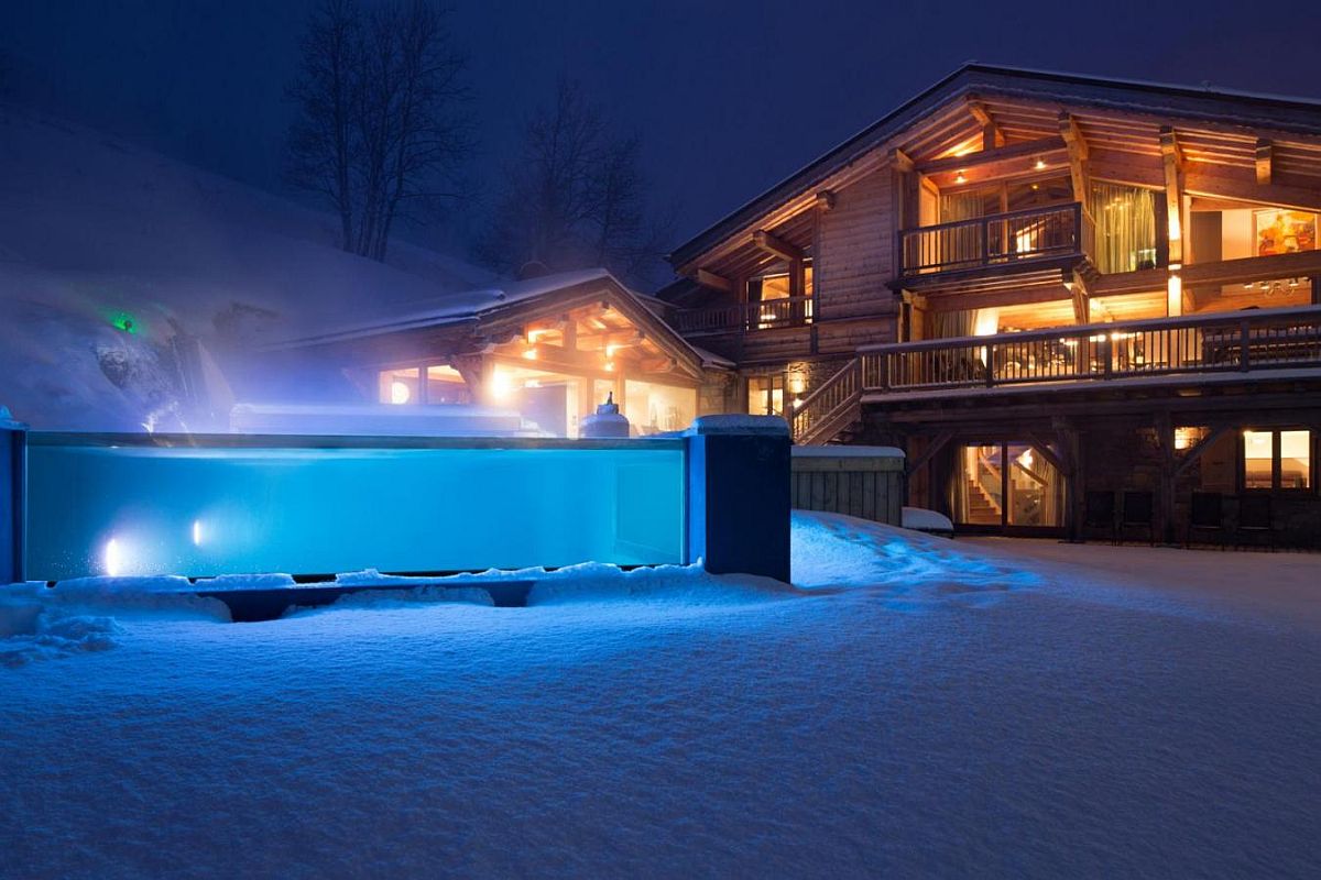 Glass-walled and heated infinity pool outside the chalet