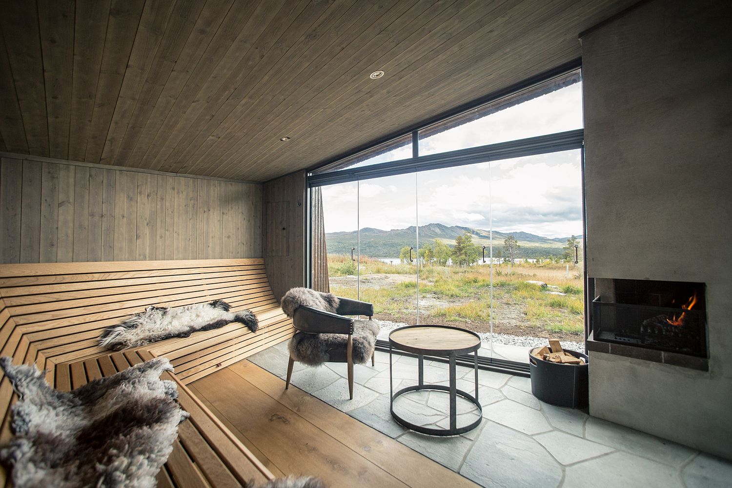 Interior of the cabin with lovely seating that offers a view of the landscape beyond