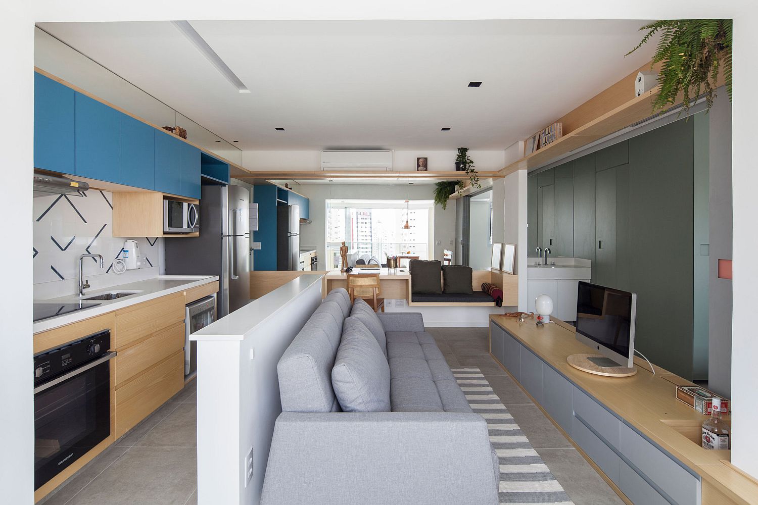 Light-filled living area of the Sao Paulo apartment with low-slung furniture and smart wall system