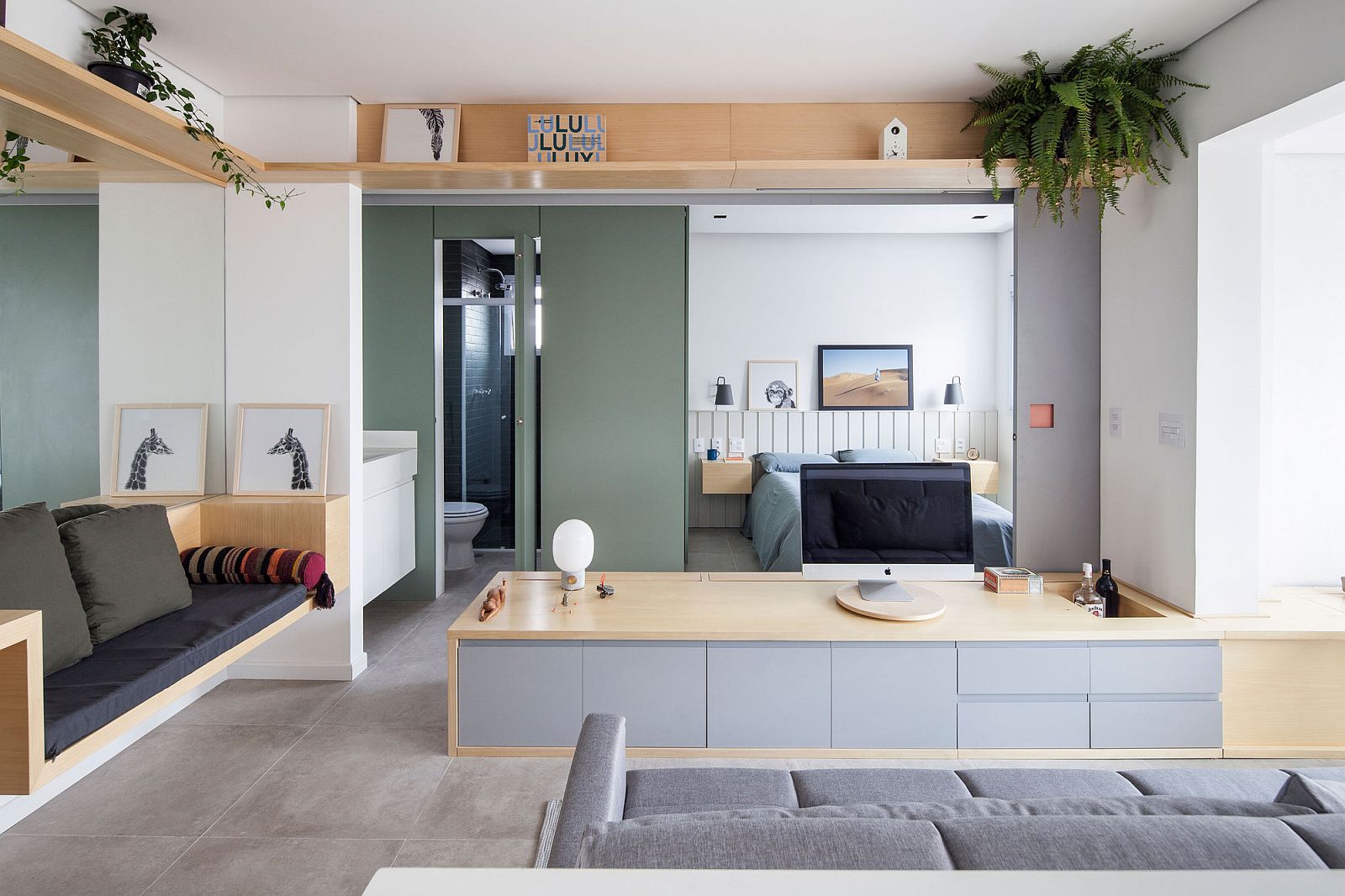 Sliding doors in green open to reveal the bedroom and the bathroom