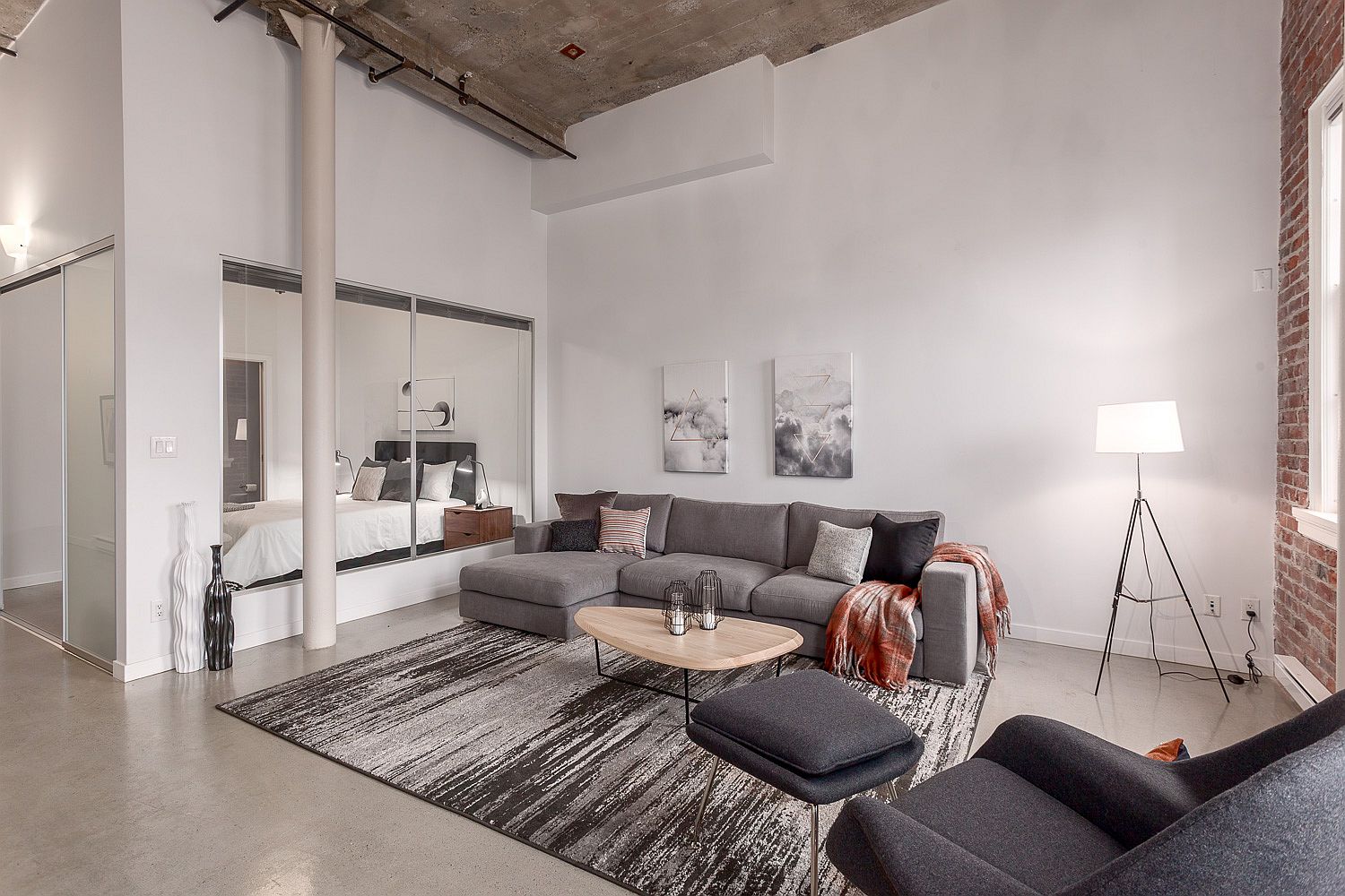 Sliding glass and mirrored doors create the small and space-savvy bedroom next to the living area