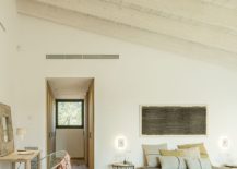 Sloped-ceiling-for-the-bedroom-with-wooden-decor-and-a-small-workspace-217x155