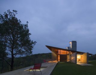 Cozy Minimal Retreat in Stone and Wood Engulfed in an Evergreen Forest