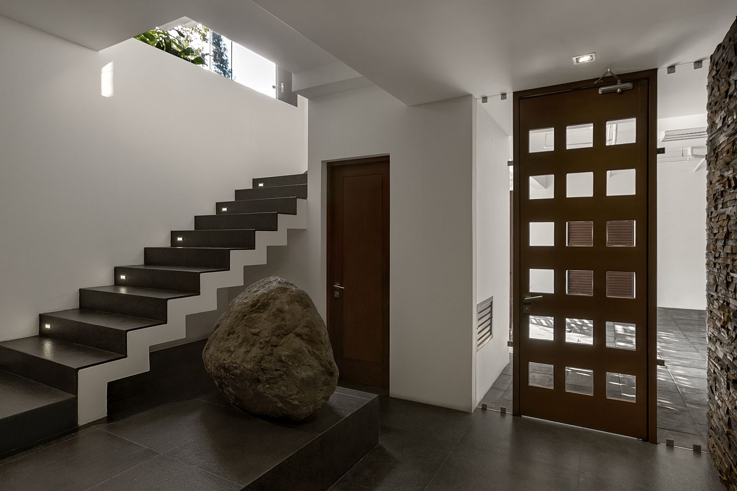 Large boulder and illuminated stairway inside the San Isidro House