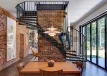 Metallic-spiral-staircase-and-exposed-brick-walls-steal-the-show-on-the-lower-level-living-room-217x155