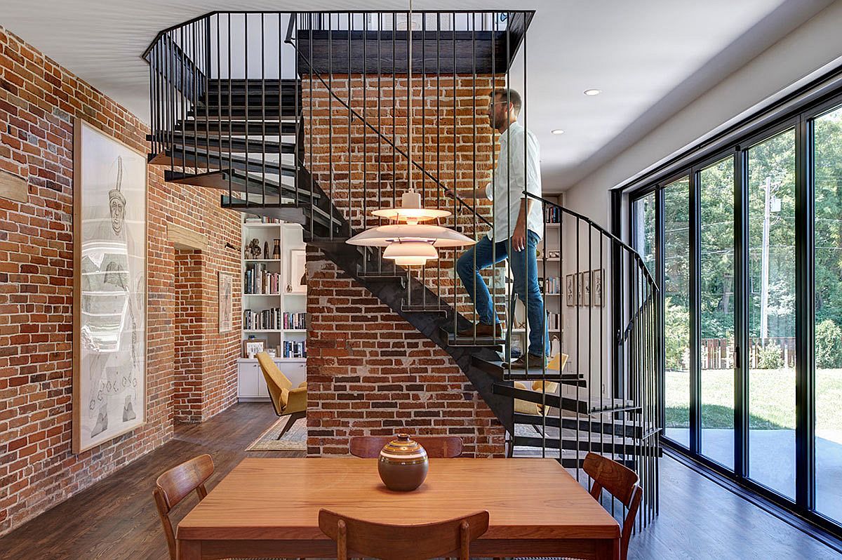 Metallic spiral staircase and exposed brick walls steal the show on the lower level living room