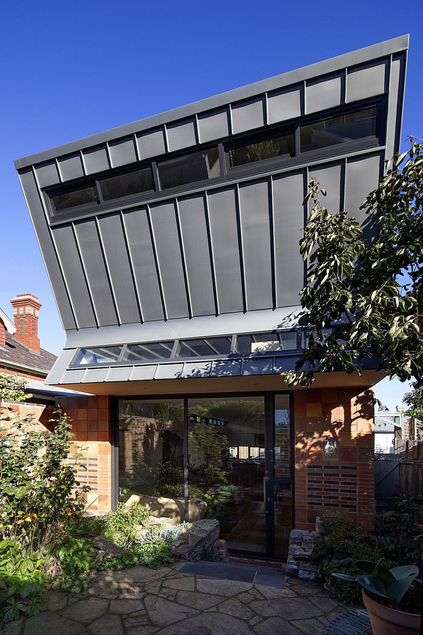 Metallic upper level sits in contrast to the brick lower level