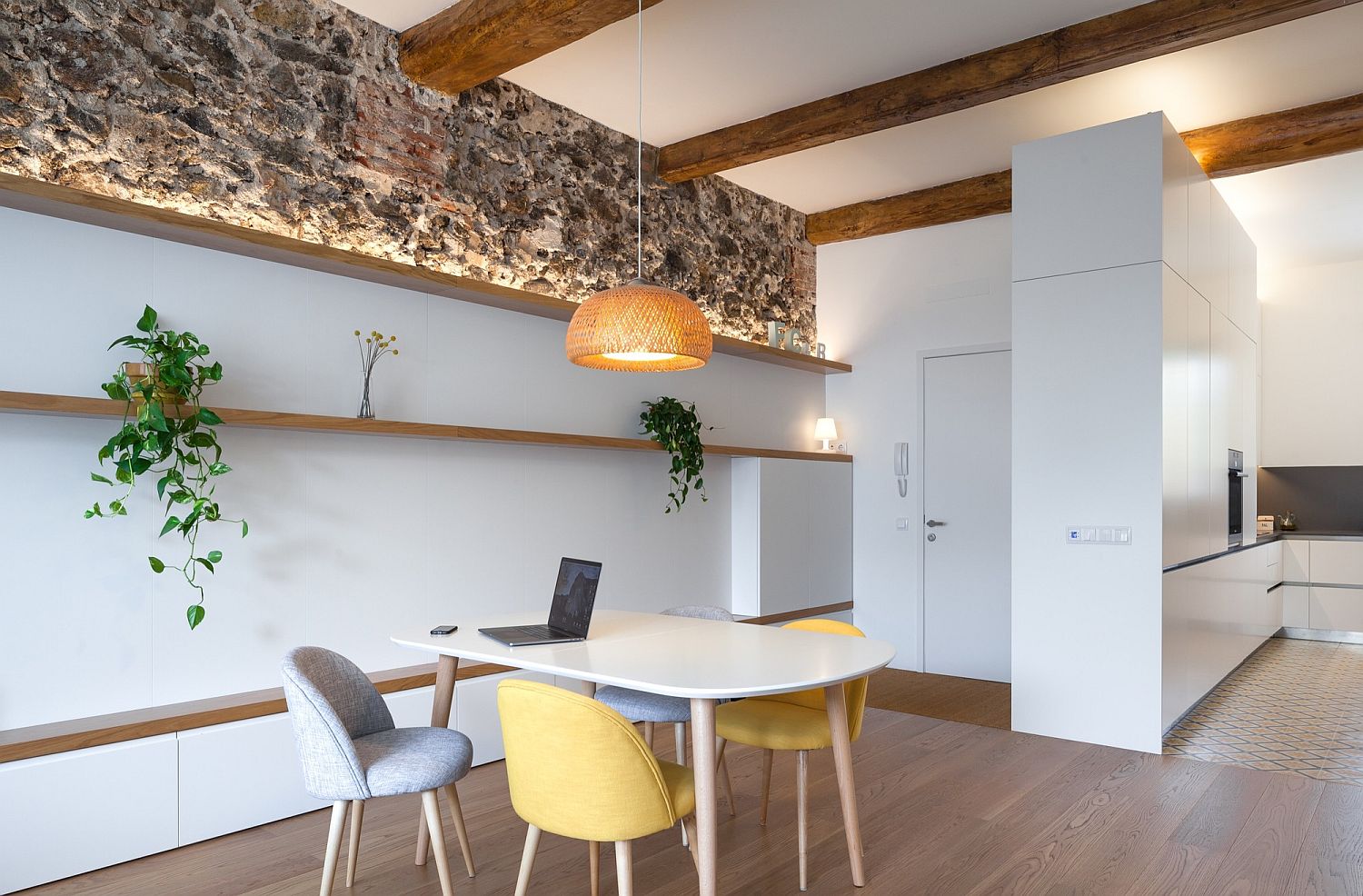 Rough stone finishes coupled with polished white surfaces and wooden ceiling beams