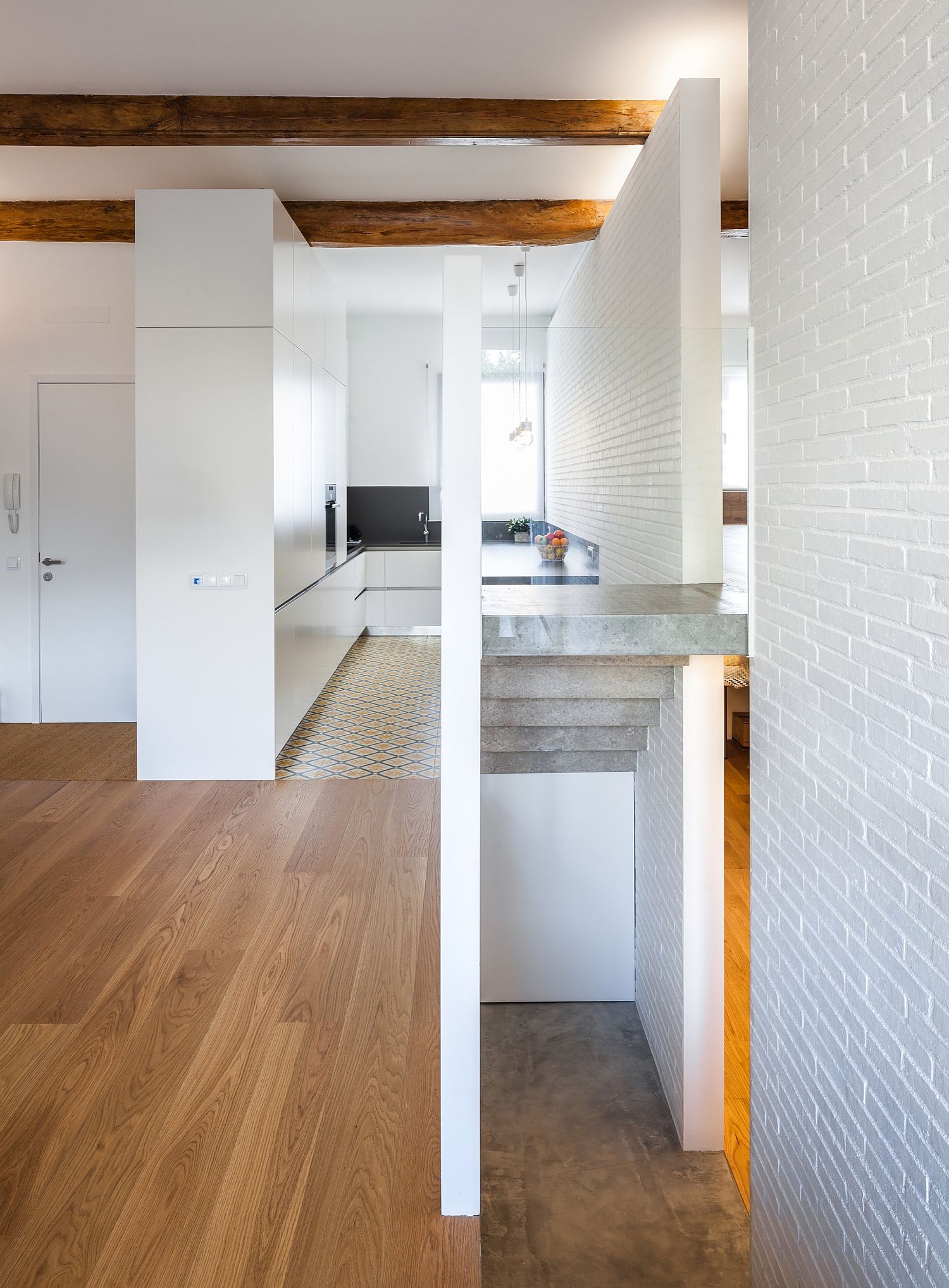 Small-corner-kitchen-in-white-with-wooden-flooring