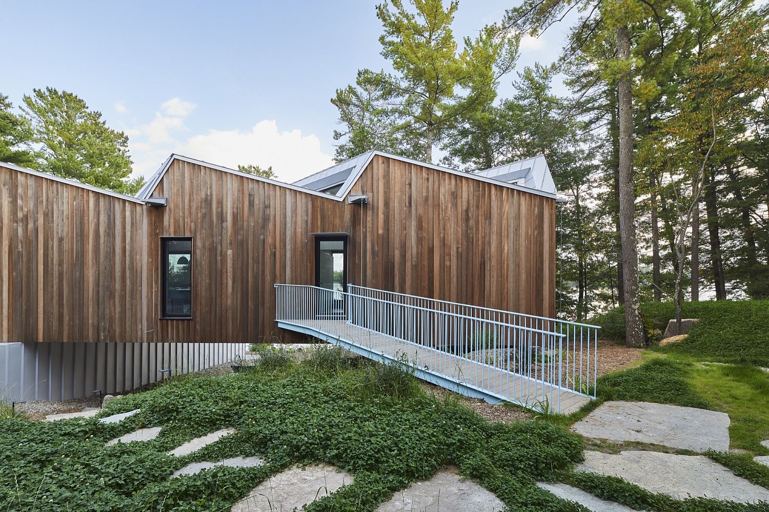 Cantilevered top level of the home connected with the landscape outside