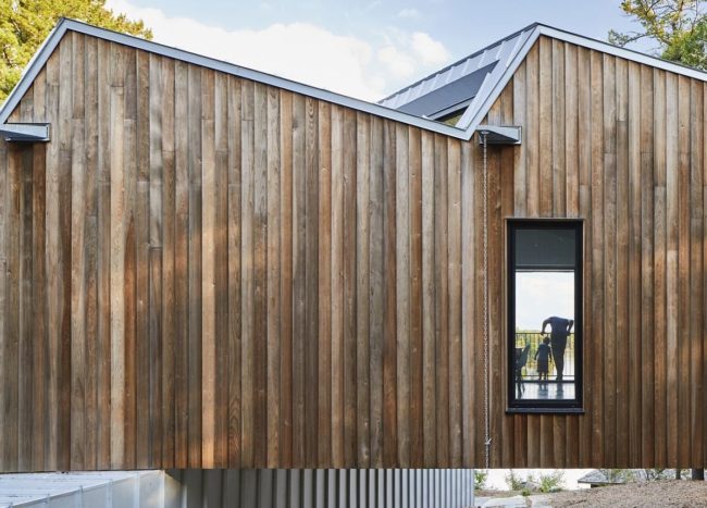 Lakeside Sky House with Reflective Metal Roof and a Cantilevered Volume ...