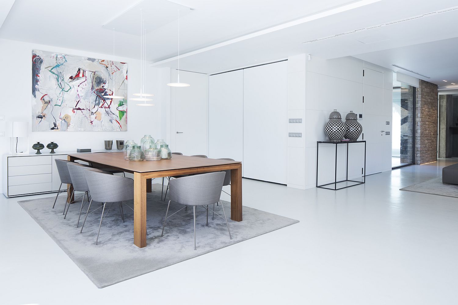 Contemporary dining room in white with a wooden table