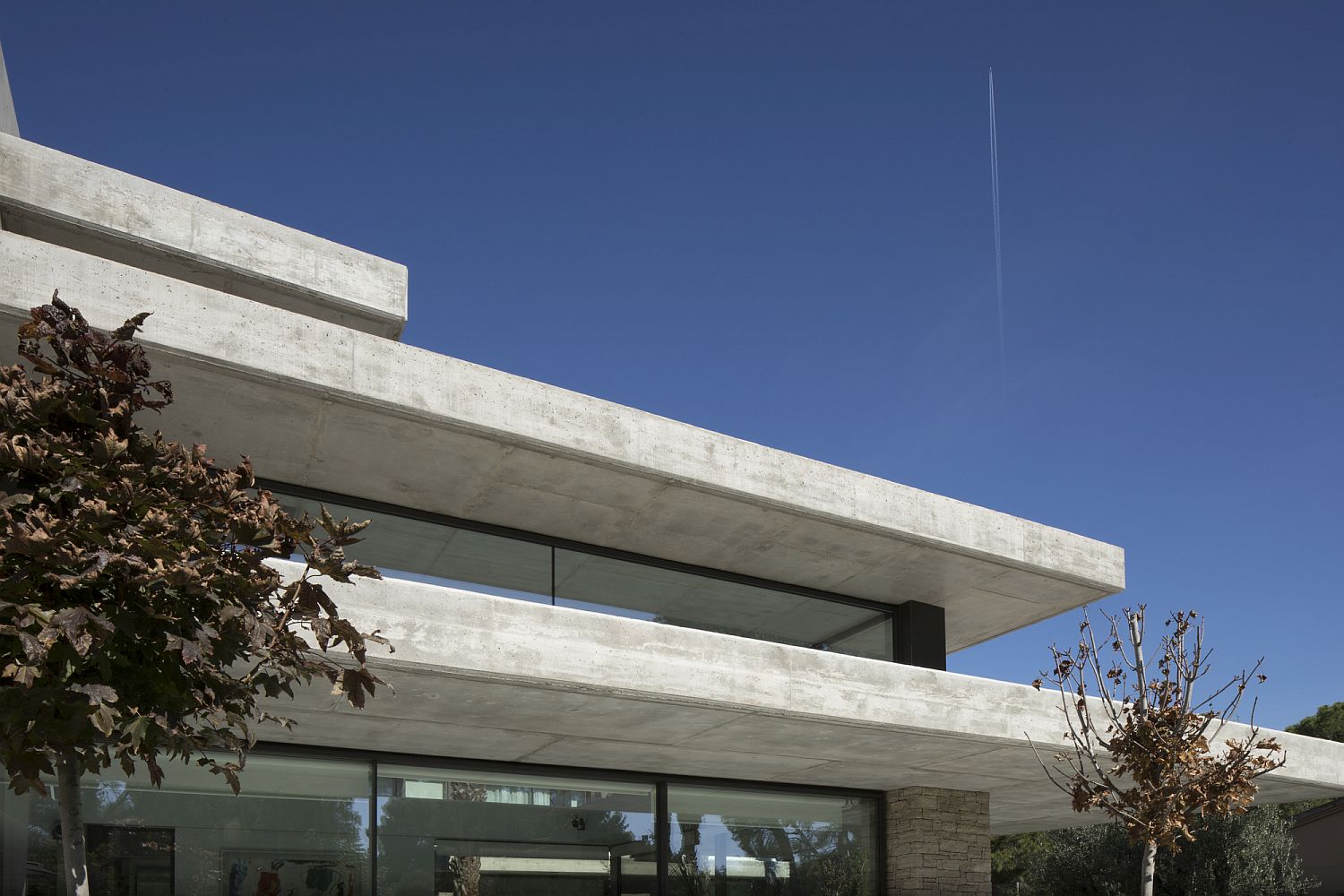 Horizontal planes of concrete between glass walls creates a cool contemporary home