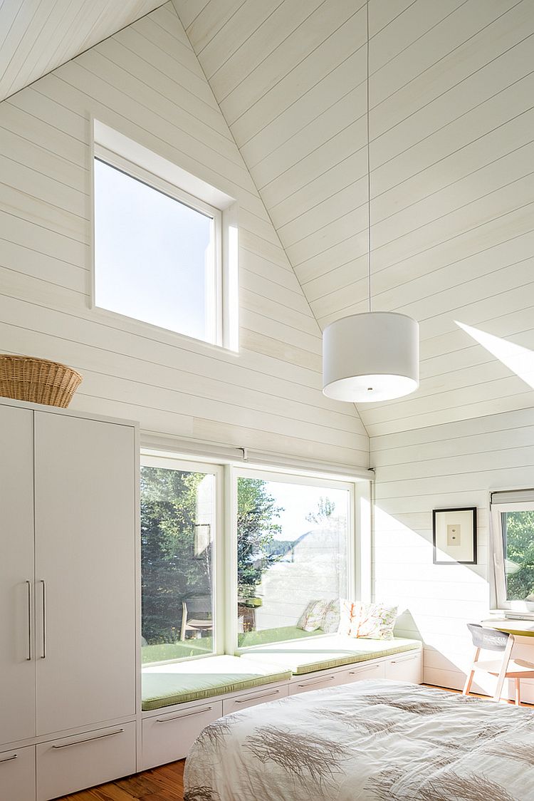 Light-filled bedroom of the house in white with a comfy window seat