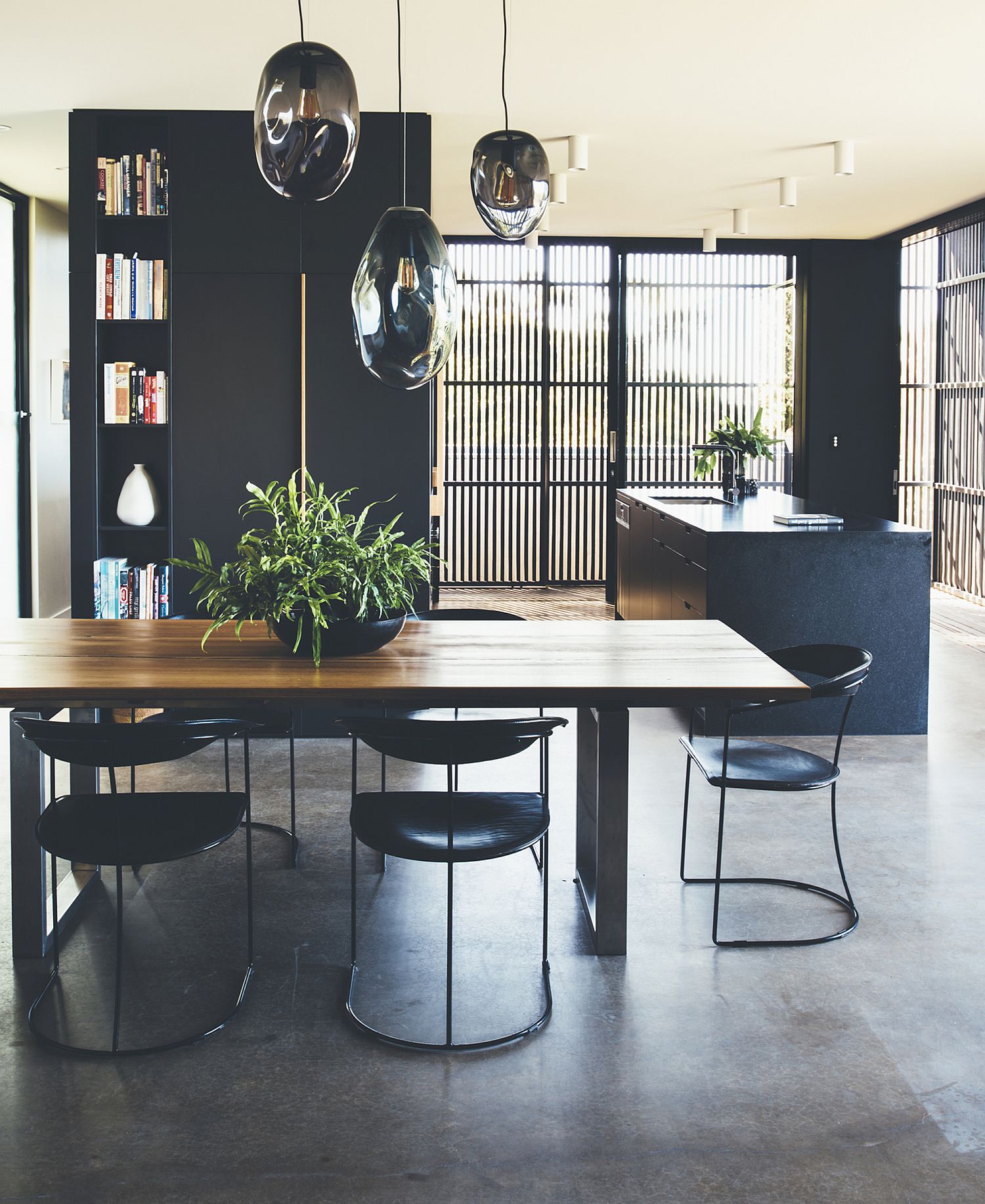 Reflective pendant lights above the dining table act as eye-catching sculptural additions