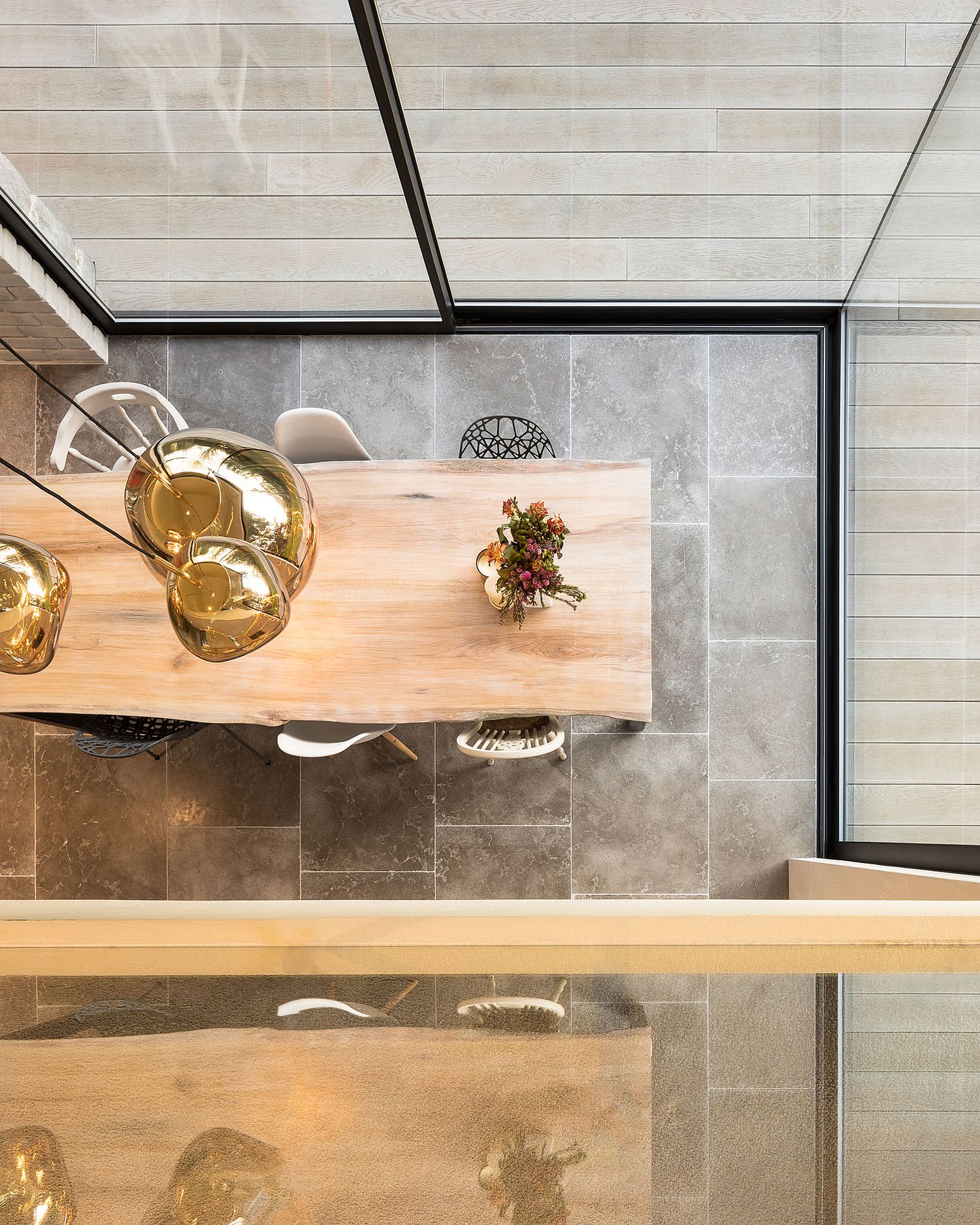 View of the dining area with natural edge table and copper pendants from above