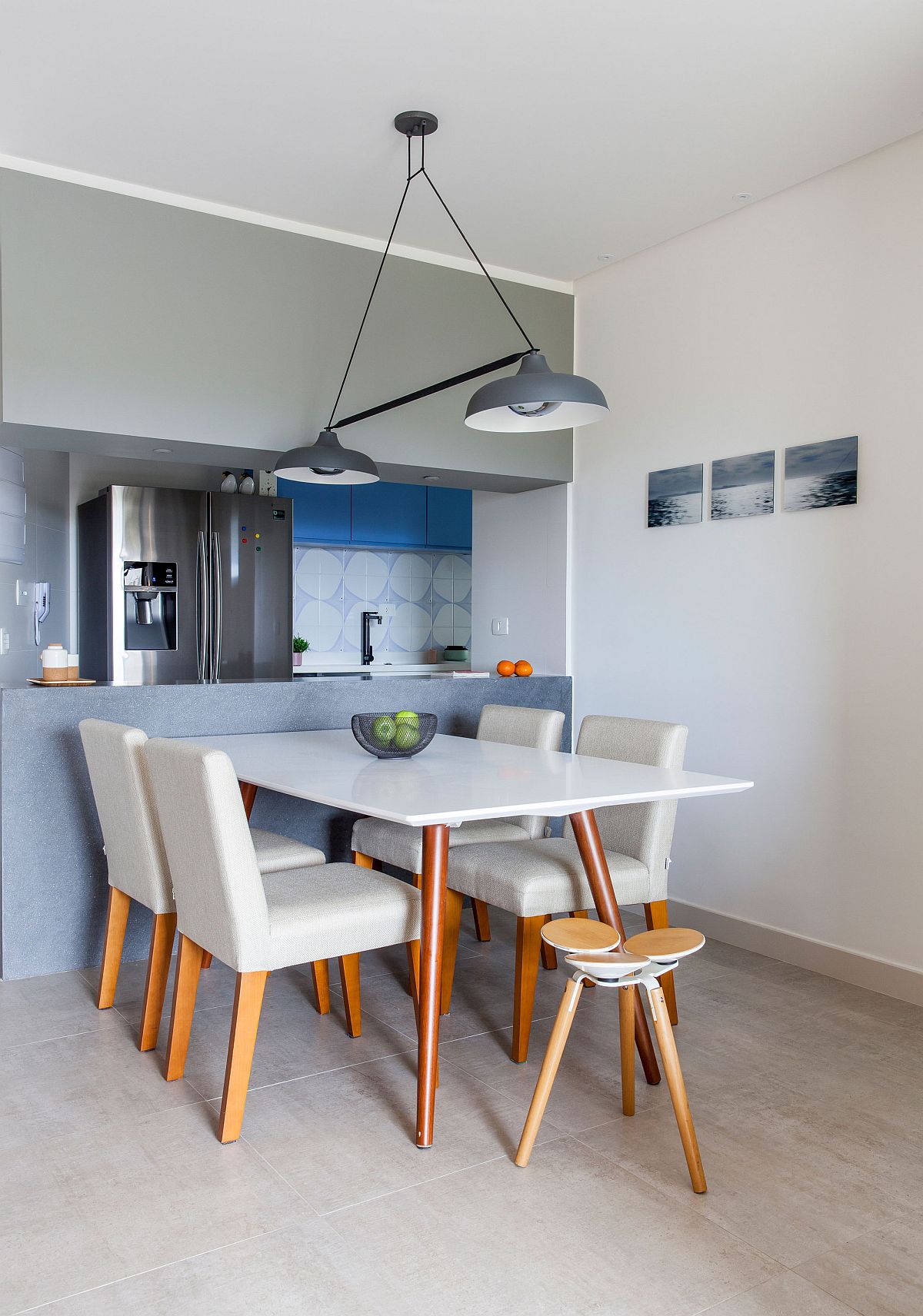 Contemporary dining room in white next to the kitchen in blue and white