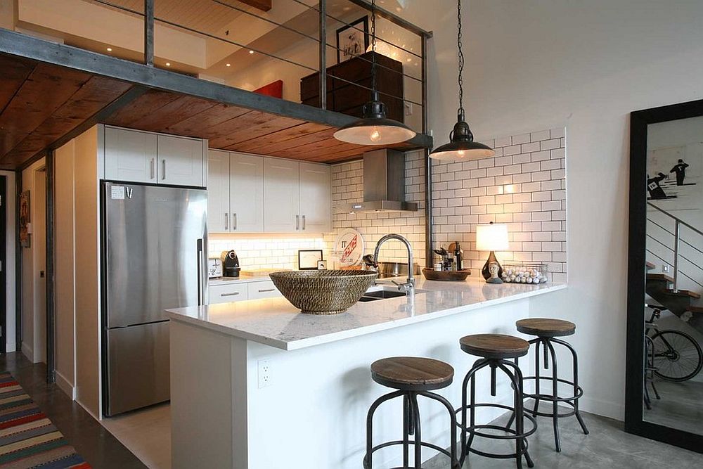 Industrial style kitchen with a simple mezzanine level above that overlooks the living area