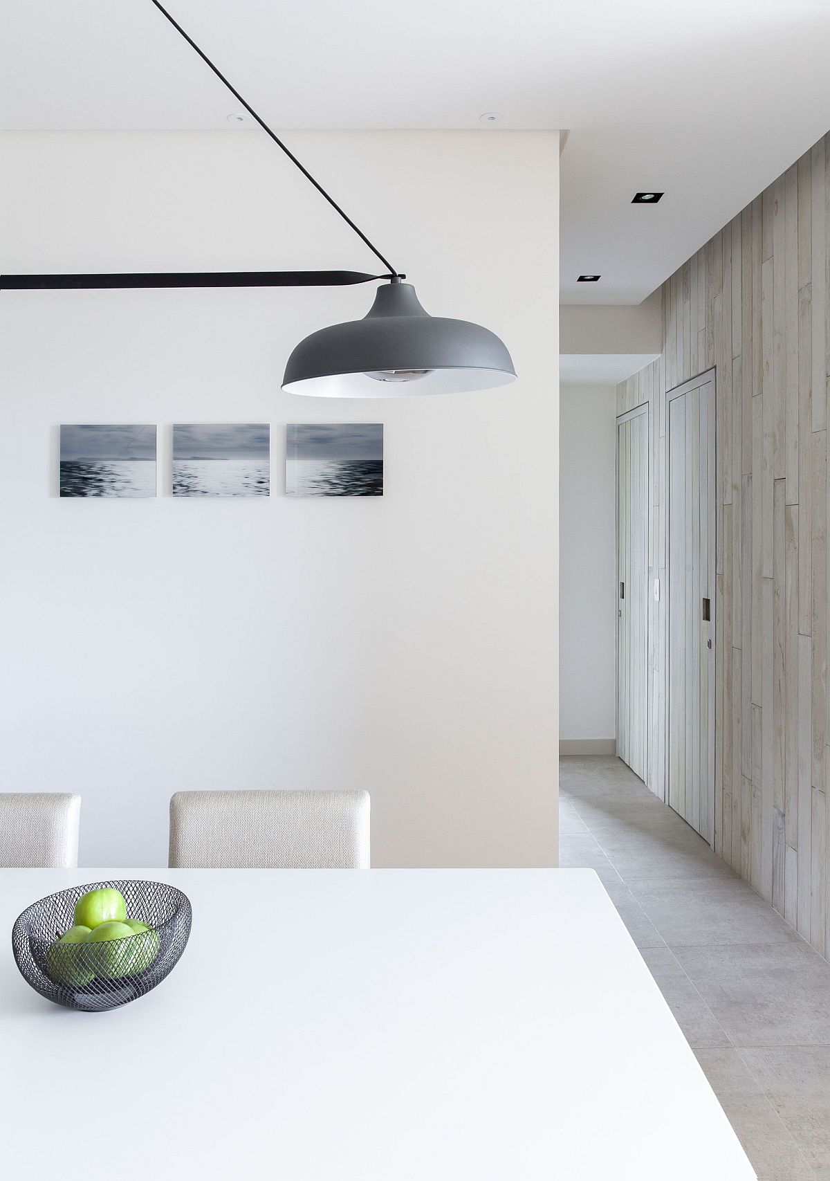 Minimal and modern dining room in white with gray pendant lighting