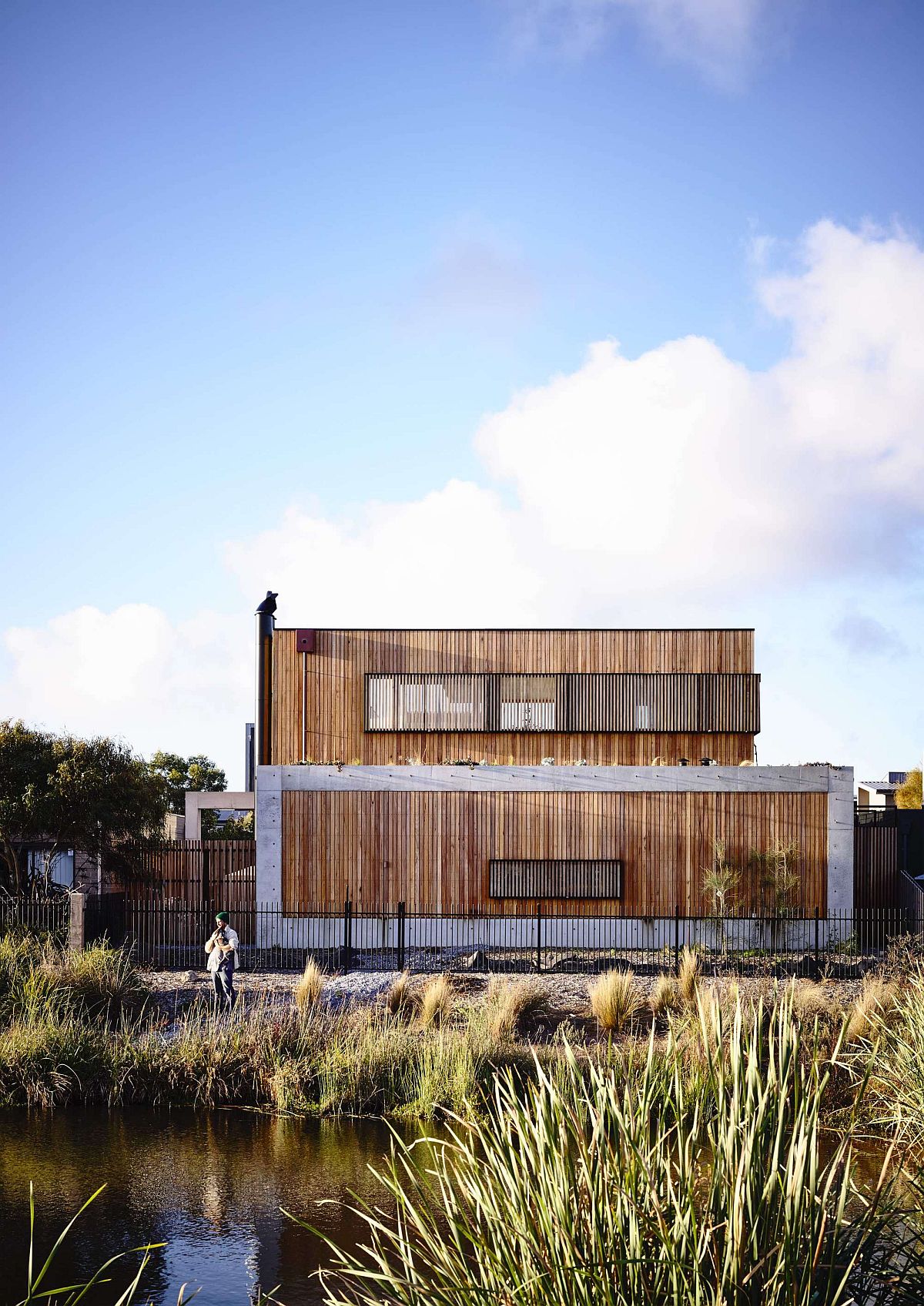 Wetlands and a golf course surround the dashing concrete and hardwood home