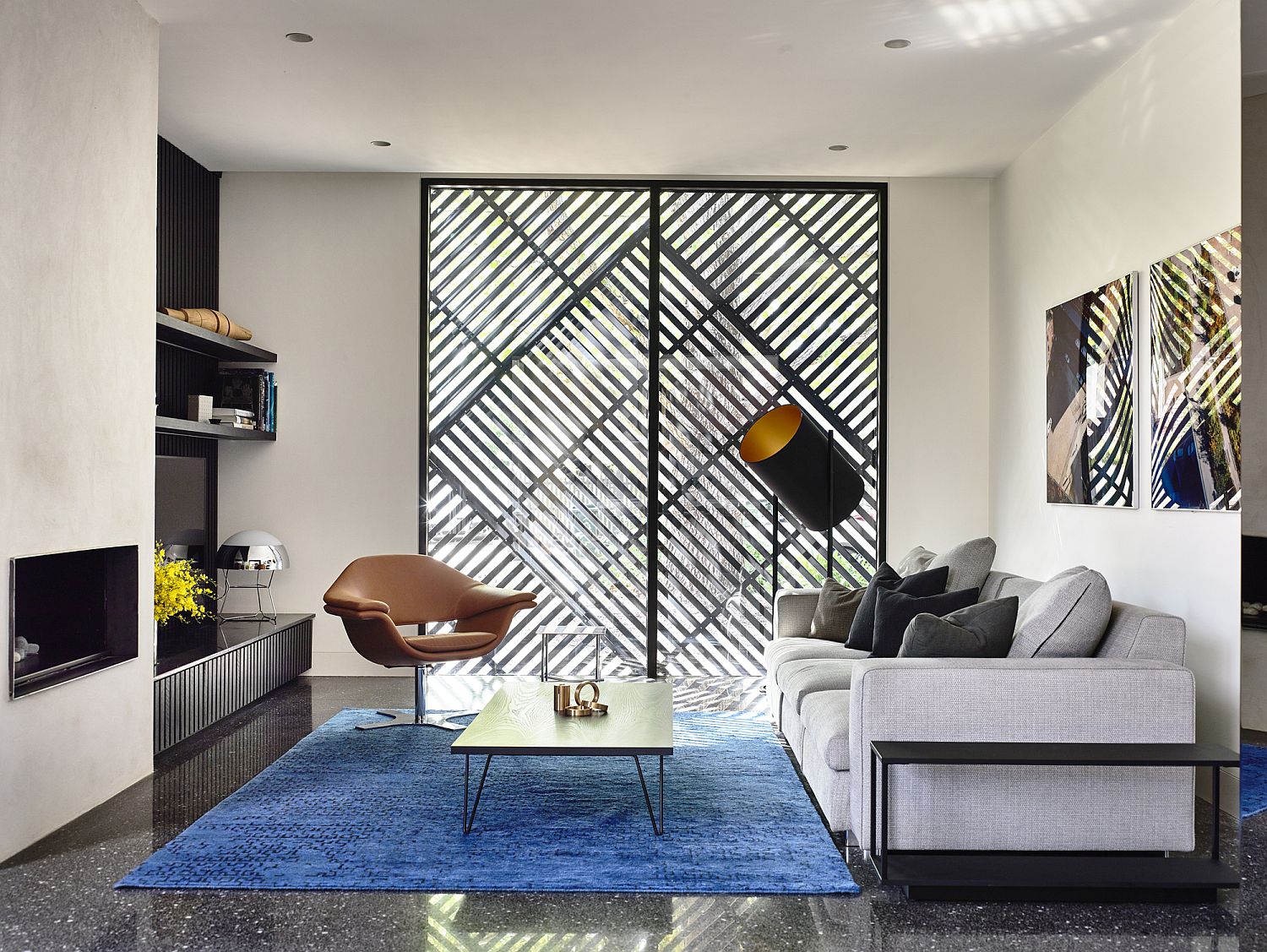 Small and stylish living area in white and black with rug adding a dash of blue
