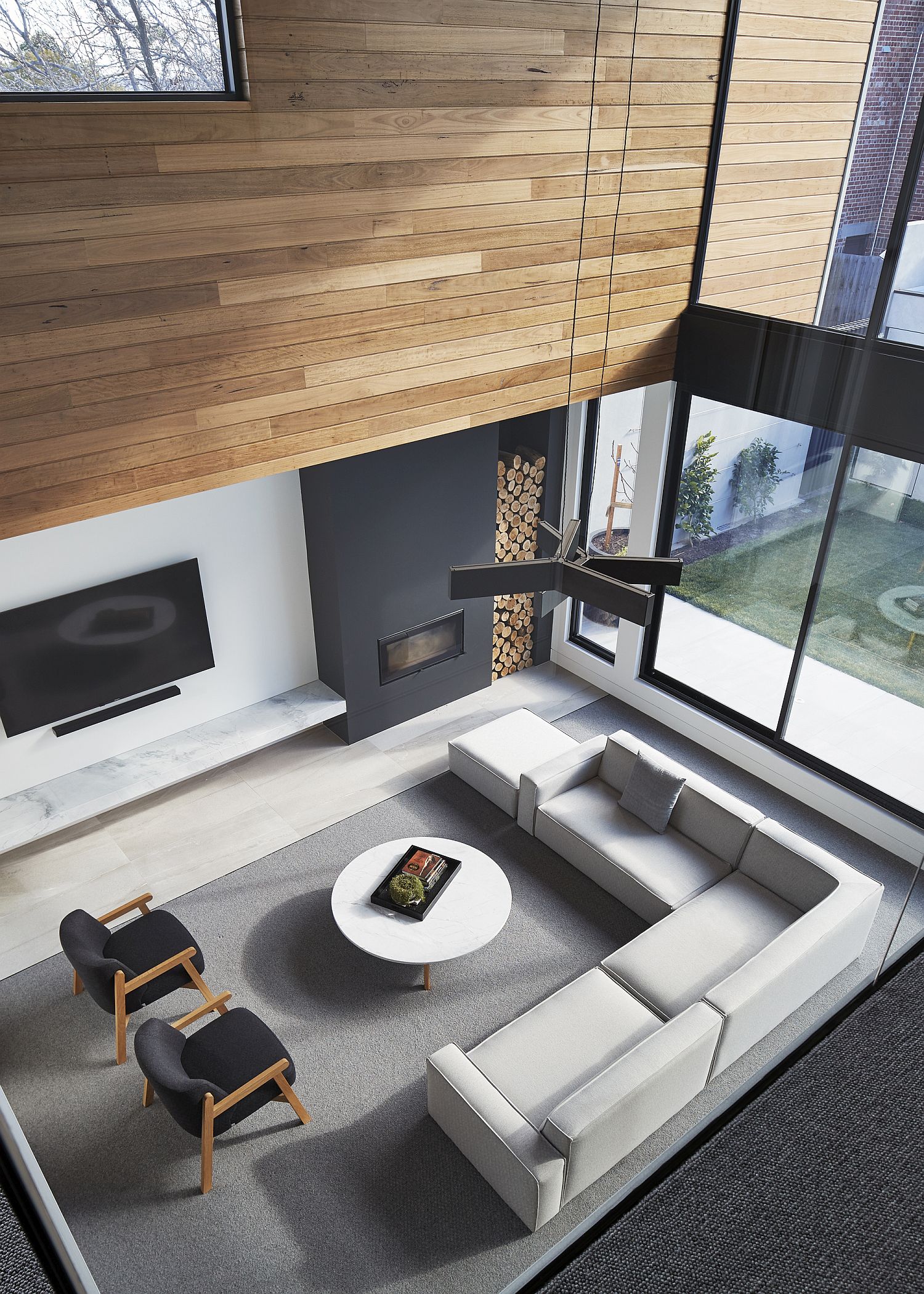 View of the double height living area with gray fireplace and slim TV unit