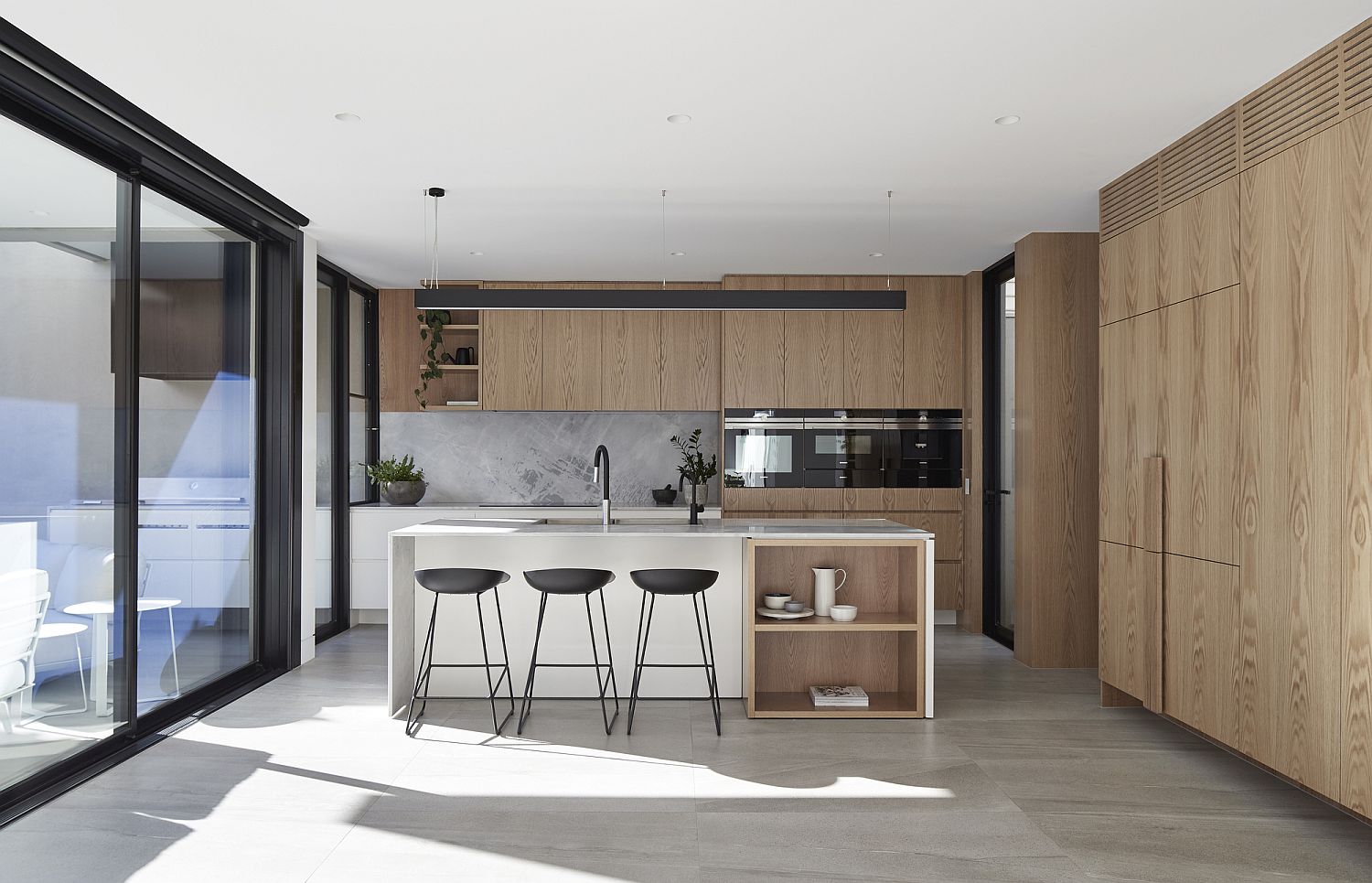 Wooden cabinets and elements bring warmth to the contemporary kitchen