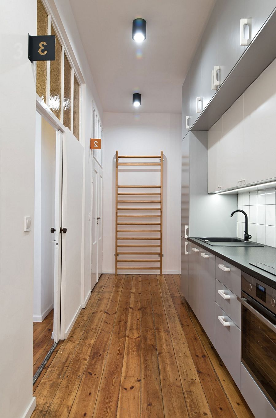 A galley-way apartment kitchen with modern appliances. 