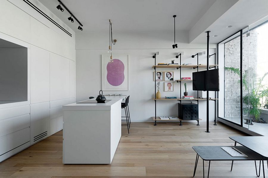 Multi-tasking living room of historic Tel Aviv apartment with stone wall sections