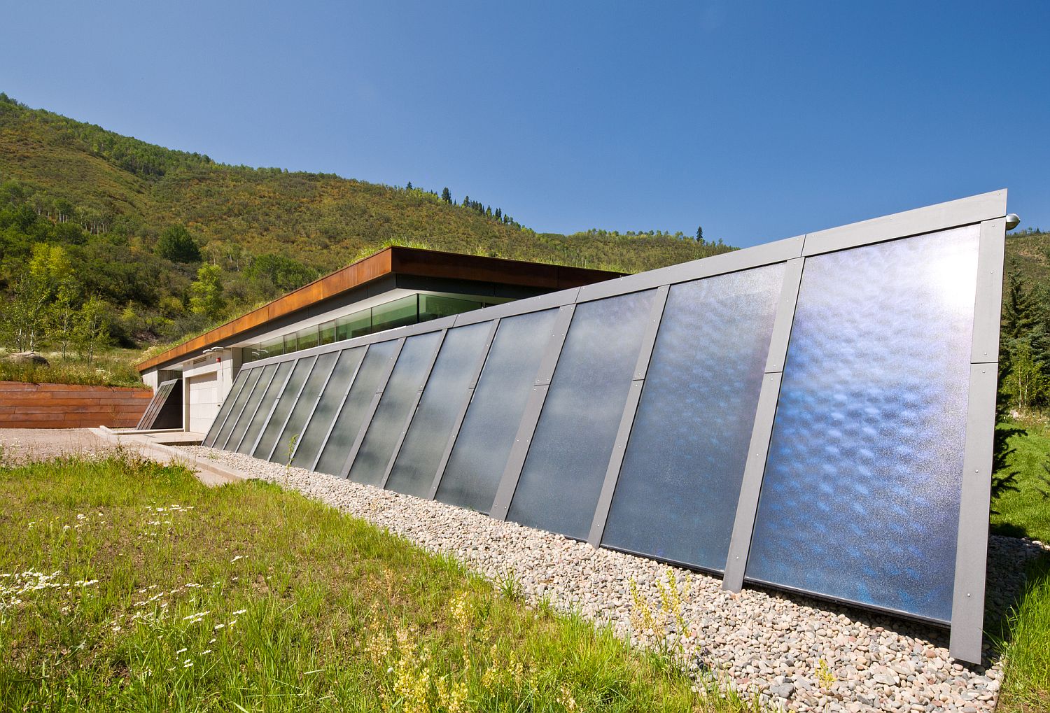 Photovoltaic panels coupled with a green roof create a lovely green home