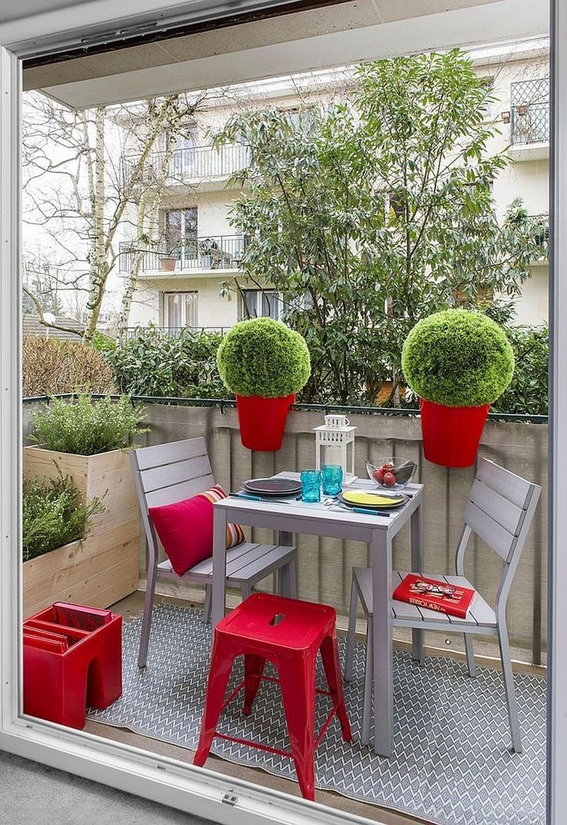 Planters on the rail and tiny table and chairs transform the small balcony into a cool hangout