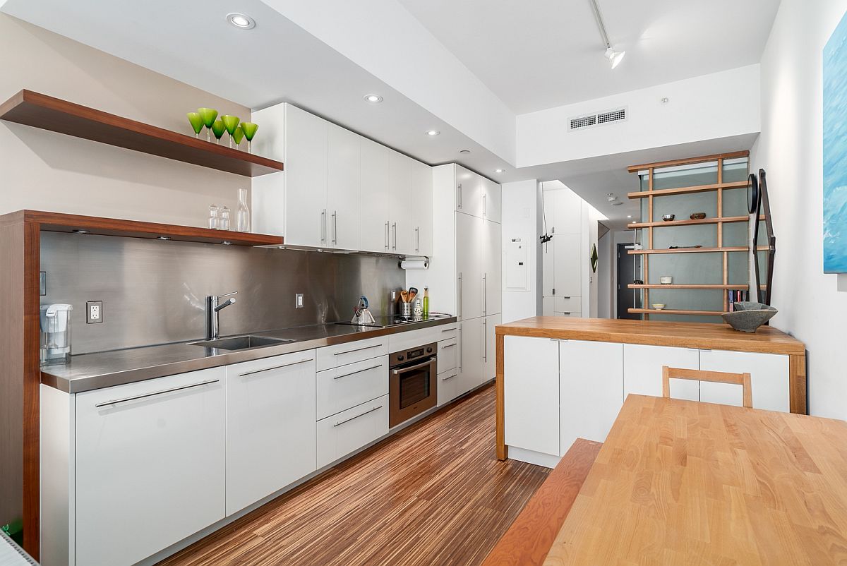 Steel-backsplash-brings-brightness-to-the-small-kitchen-of-Vancouver-apartment