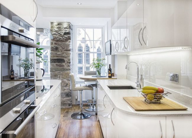 50 Tiny Apartment Kitchen Ideas That Excel At Maximizing Small Spaces   Stone Wall Section Adds Character To The Tiny Kitchen In White 650x467 