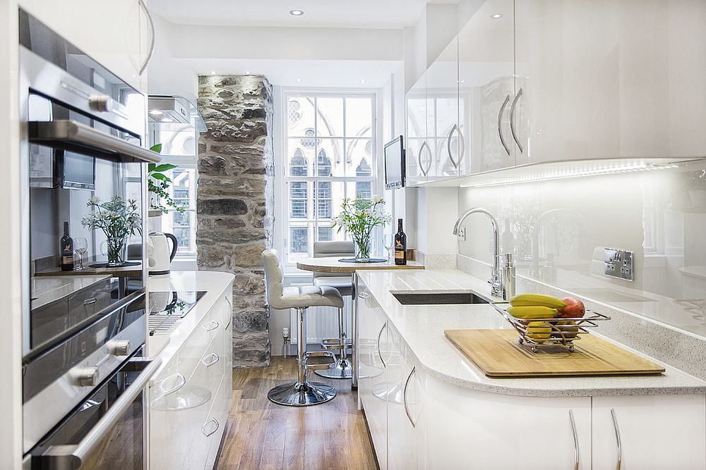 Stone wall section adds character to the tiny kitchen in white