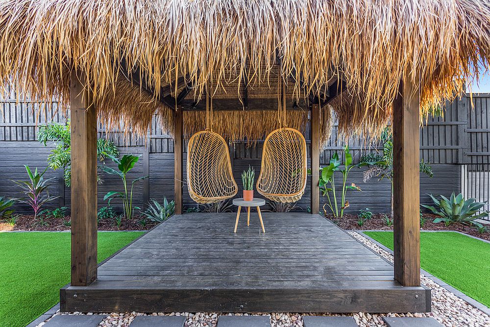 Tropical escape inspired outdoor deck with hanging seats