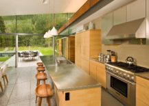 Wood-and-metal-kitchen-with-a-view-of-the-pool-outside-217x155