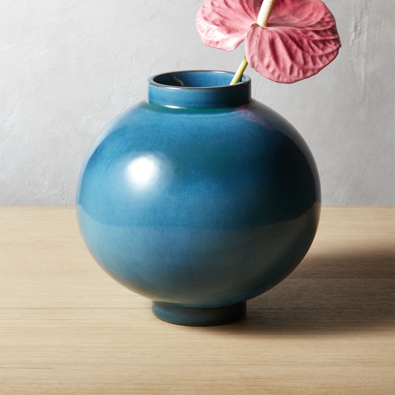 Blue teal vase with tropical foliage