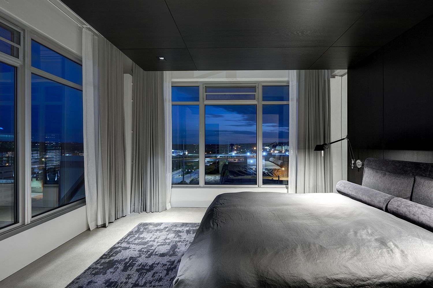 Dark wooden ceiling stands in contrast to the walls in white in the bedroom