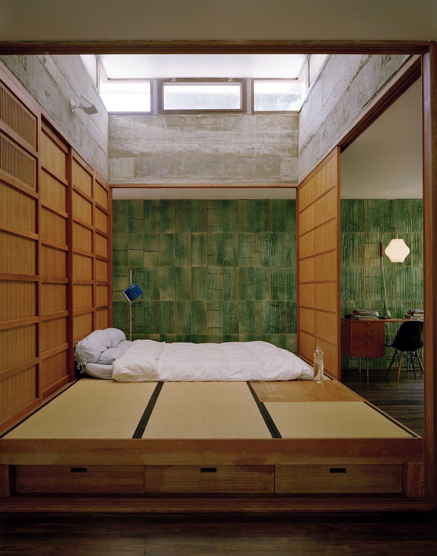 Minimal Asian style bedroom with green walls and a woodsy platform bed