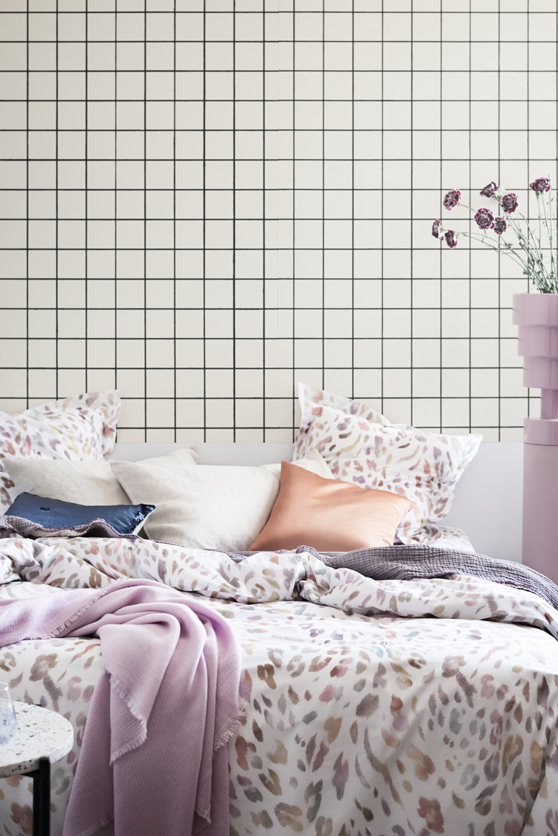 Navy-and-lilac-hues-stand-out-in-this-comfy-artful-bedding-vignette