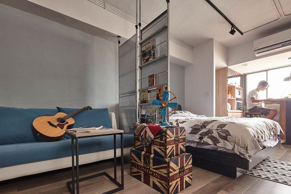 Small glass partition separates the living room from the bedroom inside this tiny apartment