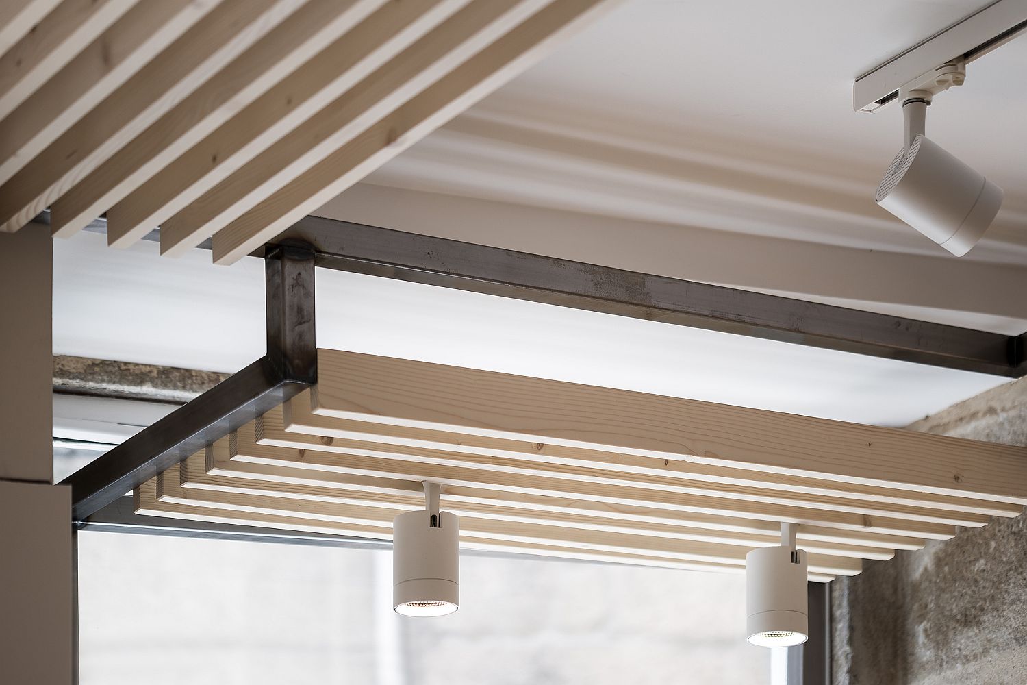 Wooden ceiling features and contemporary lighting of the restaurant